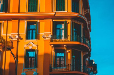 orange corner building with green wooden windows