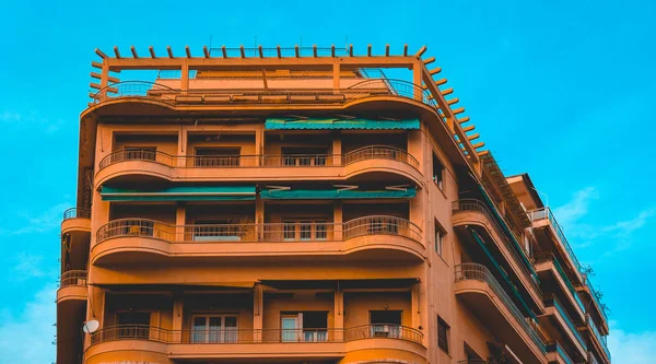 Majestueux immeuble d'appartements orange avec ciel bleu propre — Photo