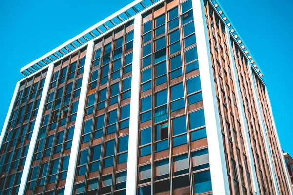 typical office complex in square form with blue windows and white facade