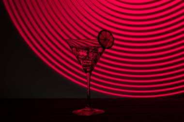 Buzlu ve neon ışıkta zeytinli bir bardak martini.