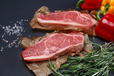 Tatlı biber, tuz ve biberiye arka plan ile Striploin biftek