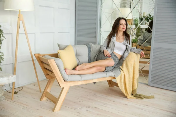 Young beautiful woman sitting on bed at home — Stock Photo, Image