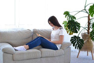 Oturma odasında bir kitap okur