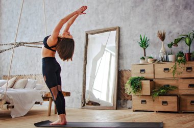 Genç, çekici, gülümseyen kadın yoga yapıyor.