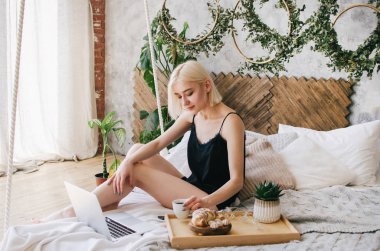 Genç kız sabah yatakta kahve içecekler