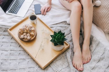 Bir tepsi, hoş kokulu kahve ve kruvasan yatakta kahvaltı