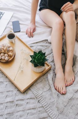 Bir tepsi, hoş kokulu kahve ve kruvasan yatakta kahvaltı