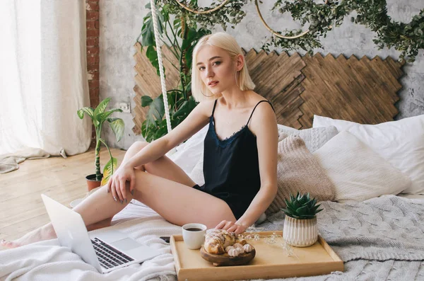 Genç kız sabah yatakta kahve içecekler