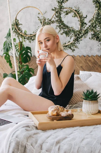 Genç kız sabah yatakta kahve içecekler