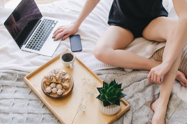 Breakfast in bed on a tray, fragrant coffee and croissants