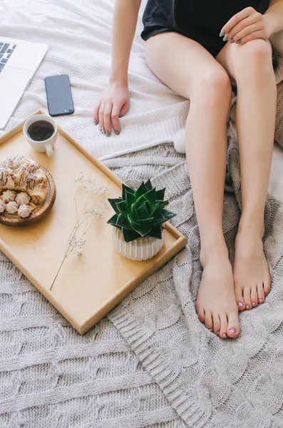 Bir tepsi, hoş kokulu kahve ve kruvasan yatakta kahvaltı