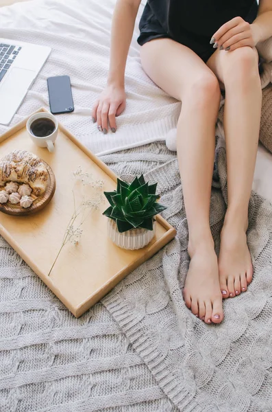 Bir tepsi, hoş kokulu kahve ve kruvasan yatakta kahvaltı