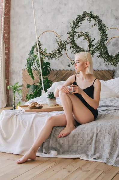 年轻女孩喝早晨咖啡在床上 — 图库照片