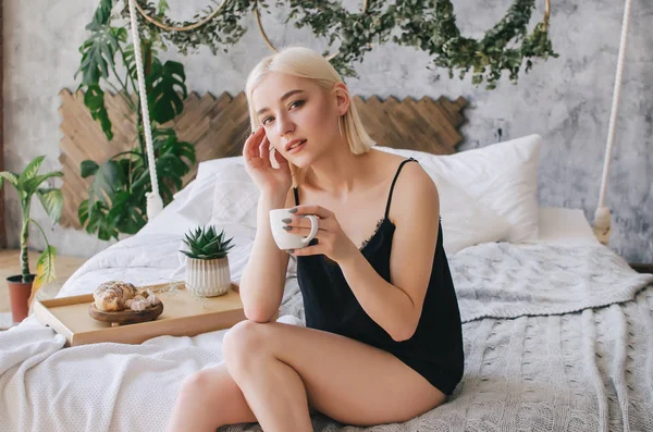 Genç kız sabah yatakta kahve içecekler