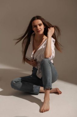 Kameraya poz veren genç bir kız. Beyaz gömlekli güzel kız.