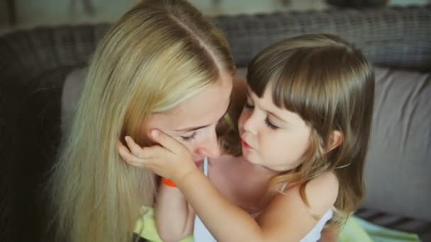 Giovane madre con la sua piccola figlia che si bacia sul divano — Video Stock