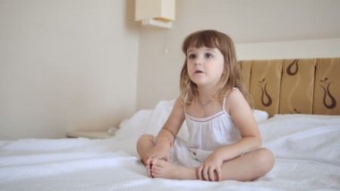 Beyaz elbiseli yatağa tv izlerken çok güzel çocuk