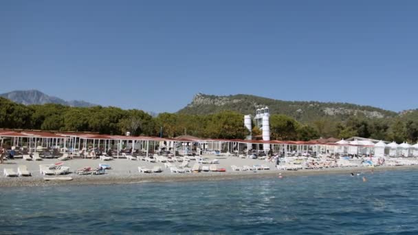 Lidé jsou opalování na oblázkových a koupání na pláži na pobřeží Středozemního moře — Stock video