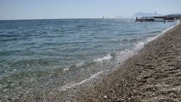 Onde su una spiaggia di ciottoli primo piano con riflesso del sole nelle onde, Mar Mediterraneo — Video Stock