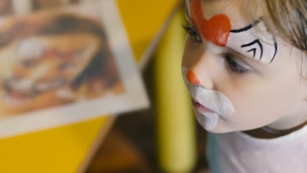 Little girl get painted face as a cat for a carnival — Stock Video