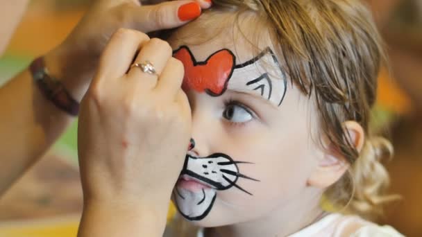 少女はカーニバルの猫のように顔を塗られて得る — ストック動画