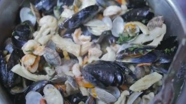 Pot ile deniz ürünleri istiridye makarna için karıştırma bir mutfak şefi