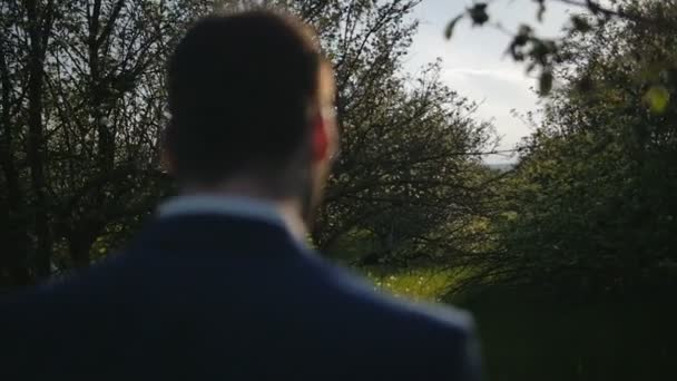 Brudgummen våren promenadpark med träd närbild av axlar och huvud skott slowmotion — Stockvideo