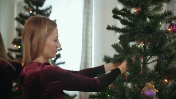 Mooie jonge dame Versier de kerstboom — Stockvideo