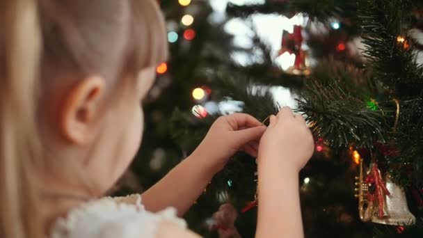 Roztomilá holčička zdobí vánoční strom. — Stock video