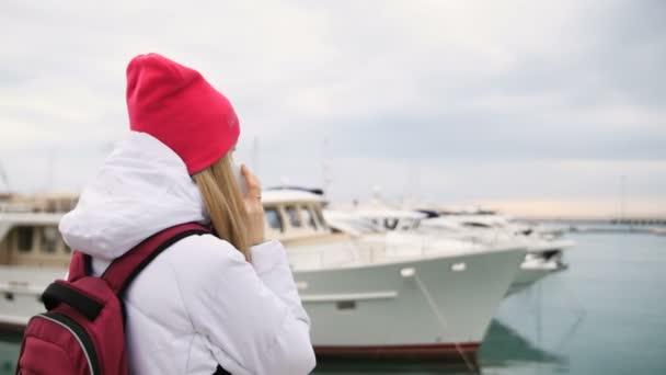 年轻漂亮的白人女孩，站在码头船与会谈到手机 — 图库视频影像