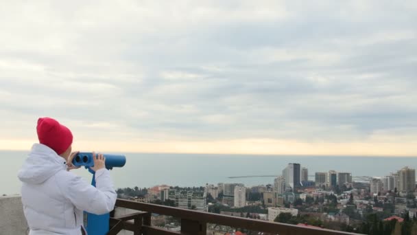Ung kvinna turist ser på staden från observationsdäck. — Stockvideo