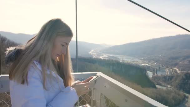 Femme utilise smartphone avec vue imprenable sur la vallée sur le fond — Video