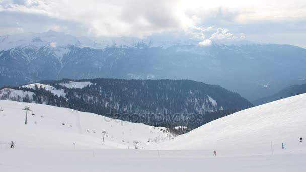 Grupp människor rida skidor och snowboards av snö lutning, vy från toppen av berget — Stockvideo