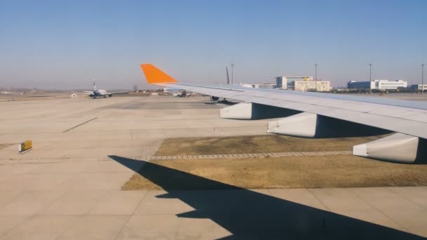 Aviones se mueven por pista de aire en el aeropuerto, vista del ala desde el interior — Vídeo de stock