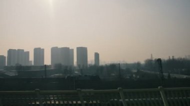 Hareket eden bir yüksek hızlı trenin penceresinden gündüz görüntüleyin. Ağır sis, karanlık smog baskıcı bir atmosfer yaratır.