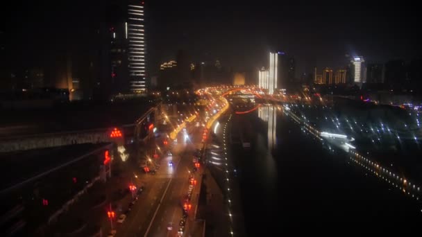 Timelapse of night city road traffic and the skyscrapers near the river — Stock Video