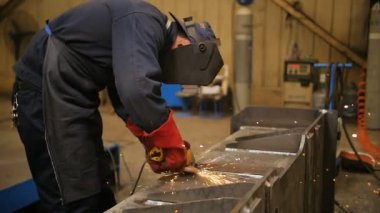 Maske işçi açı grinderon metal konstrüksiyon metal kullanın. Sparks kameranın doğru yavaş yavaş döner. Ağır çekim