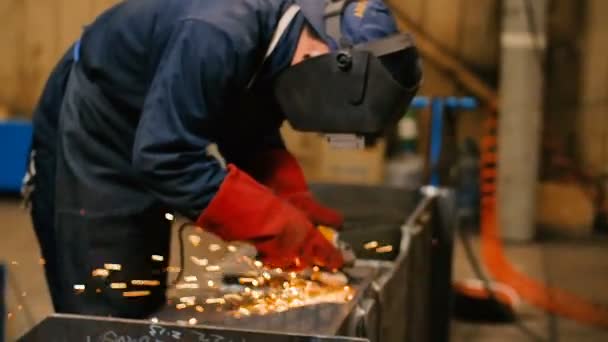 Worker in mask use angle grinderon metal construction metal. Sparks slowly turns toward the camera. Slow Motion — Stock Video