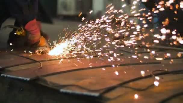 Close-up de mãos do trabalhador usar ângulo grinderon metal de construção metálica. Sparks lentamente se vira em direção à câmera. Movimento lento — Vídeo de Stock