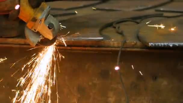 Close-up de mãos do trabalhador usar ângulo grinderon metal de construção metálica. Sparks lentamente se vira em direção à câmera. Movimento lento — Vídeo de Stock