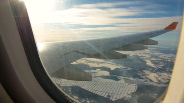 Tierra vista a través de la ventana del avión a reacción. Avión aterrizando lentamente — Vídeo de stock