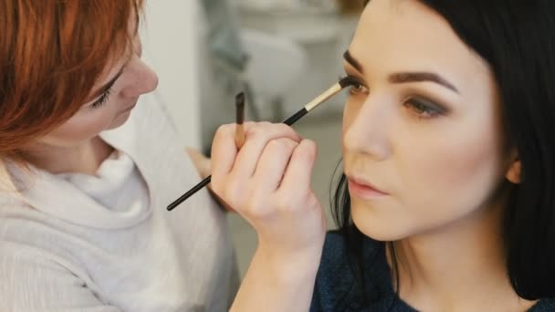 Close-up van een kunstenaar van de make-up make-up toe te passen op de wimpers — Stockvideo