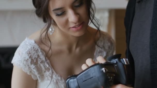 Fotós mutatja menyasszony képeket a kamera — Stock videók