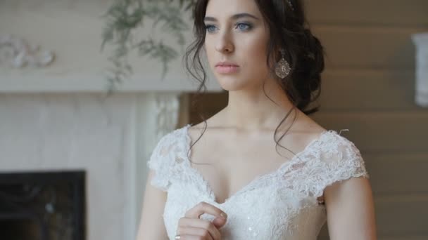 Bride in white dress staying indoors and pose for photographer — Stock Video