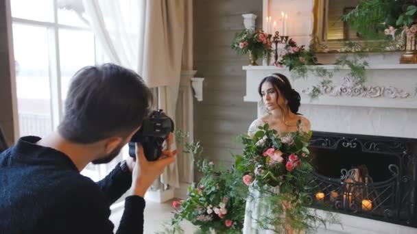 Fotografo riprese sposa con un bouquet e un camino sullo sfondo — Video Stock