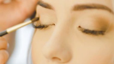Profesyonel göz makyaj sanatçısı göz farı toz uygulamak. Güzel bir kadın yüzü. Mükemmel makyaj. Güzellik moda. Kirpik. Yakın çekim