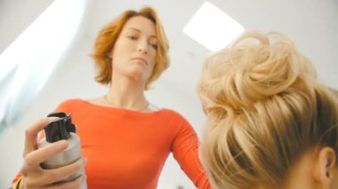 Profesyonel kuaför, saç modeli genç güzel kadın için yapıyor ve beyaz saç spreyi kullanarak stilist odayı olun. Güzellik ve saç bakım kavramı