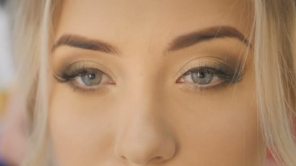 Gyönyörű szőke nő portré ragyogó kék szeme közelről — Stock videók