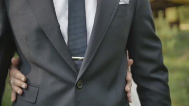 kadın el sarılmak bir adam bir gelinlikle. Kamera önünde duran bir damat elleri Close-Up