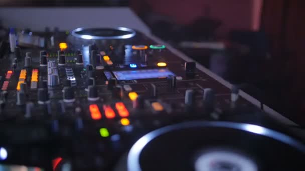 Un DJ derrière la console, sur scène, mélangeant des morceaux dans des soirées dansantes atmosphériques stroboscopiques et des lumières clignotantes . — Video